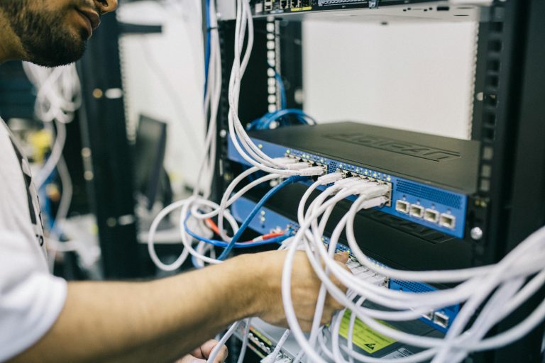 Man connecting cables to a network switch in a server rack in Shropshire